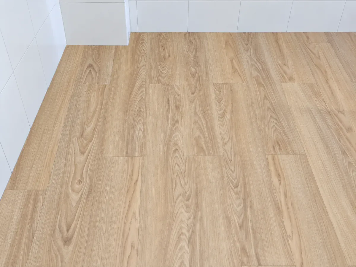 Foto pemasangan lantai vinyl Timberwood dengan papan memanjang dan sambungan ujung berselang, dengan kualitas ditingkatkan menggunakan AI